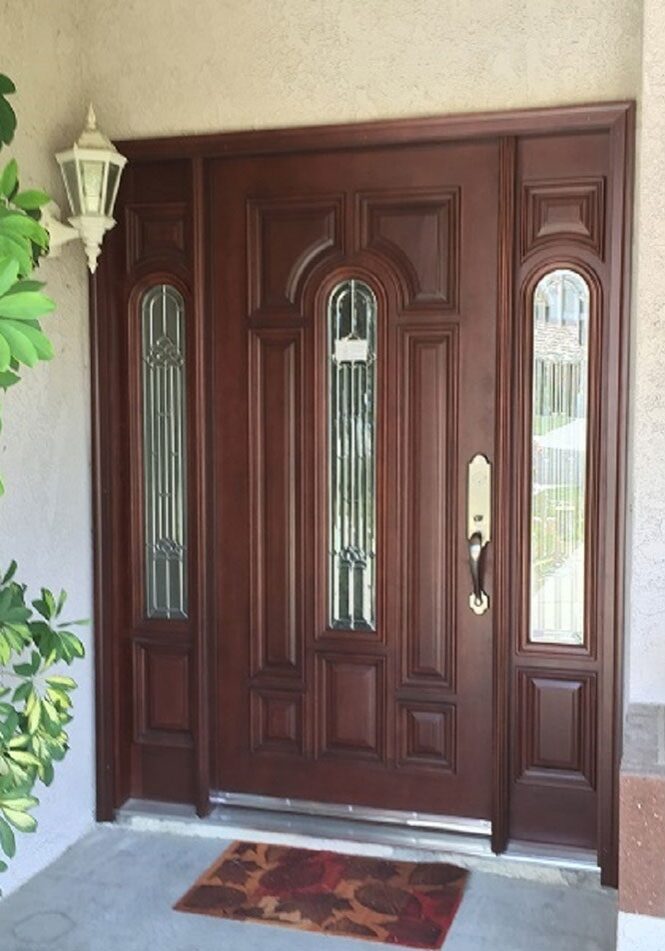 A front door with two side panels and one with glass.